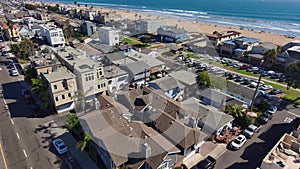 aerial footage of cars and trucks driving on the street with palm trees, homes, apartments blue ocean water and a sandy beach