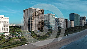 aerial footage of the coast of the Atlantic ocean with hotels and luxury condos in the city skyline at sunrise, palm trees