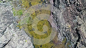 Aerial footage of colourful rocks and a water pool on the coast in regional Australia