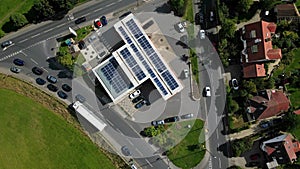 Aerial footage descending over solar panels above petrol station forecourt