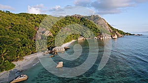 Aerial footage of famous tropical beach Anse Source d`Argent at sunset evening light. La Digue Island, Seychelles