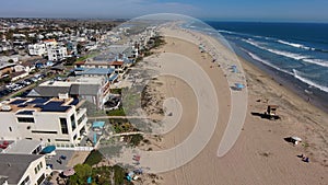 aerial footage flying along the coastline at Rosie\'s Dog Beach with people walking along the beach and cars driving