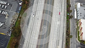 Aerial footage of a free way with cars and trucks driving on the road surrounded by lush green trees, grass and plants