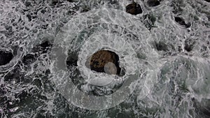 Aerial footage of the gorgeous ocean water with waves crashing into the rocks on the beach at Baby Beach in Dana Point California