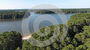 aerial footage of a gorgeous summer landscape at Proctor Landing park with green lake water, trees and grass, boats and people