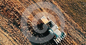 Aerial footage of harvester collecting harvest, harvesting the fields