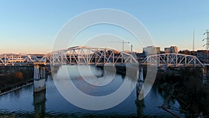 Aerial footage of the John Seigenthaler Pedestrian Bridge with people walking along the bridge surrounded by the Cumberland River