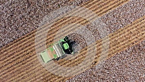 Aerial footage of a Large Cotton picker harvesting a field.