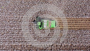 Aerial footage of a Large Cotton picker harvesting a field.