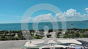 aerial footage of Miami Marine Stadium with boats and ships sailing, lush green palm trees and grass and skyscrapers and hotels