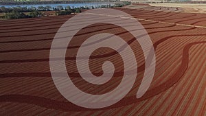 Aerial footage pattern plowing in red soil farm