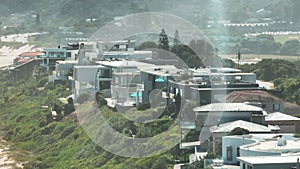 Aerial footage of row of luxurious residencies or guesthouses along sand beach on sea coast. South Africa