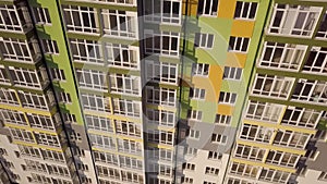 Aerial footage of a tall residential apartment building with many windows and balconies.