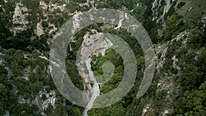 Aerial footage of a twisty mountain road and green dense forest