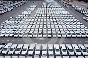 Aerial front view new cars lined up parked in a row in warehouse at the commercail dock for exporting to distributors and dealers