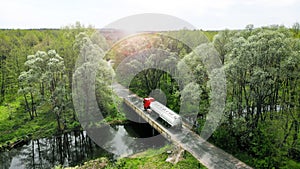 Aerial. The fuel gasoline truck is crossing the little rural bridge.