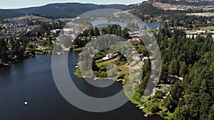 Aerial Glen Lake and Langford Lake overlooking distant development near Bear Mountain in Victoria BC Canada.