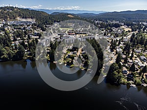 Aerial Glen lake overlooking a new condo development on Vancouver Island with Olympic Mountains at background .