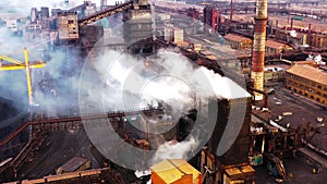 Aerial. GLOBAL WARMING. View of high chimney pipes with grey smoke. Pipes Pollute Industry Atmosphere With Smoke Ecology