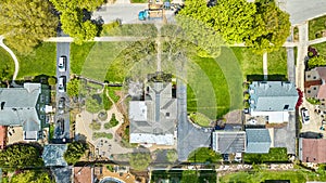 Aerial green property lawns neighborhood houses landscaping HAO construction and cars