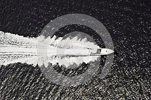 Aerial greyscale shot of a speed boat at sea in the Angra dos Reis municipality of Brasil