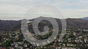 AERIAL: Griffith Observatory far away with view on Hollywood Hills in Daylight, Los Angeles, California, Cloudy