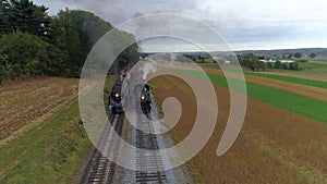 Aerial head on view of two steam locomotives steaming up side by side day