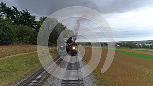 Aerial head on view of two steam locomotives steaming up side by side day