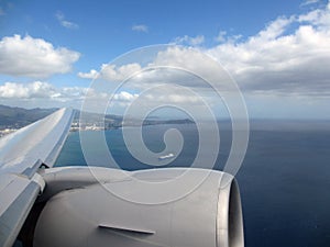 Aerial high in the sky shot of window view of plane leaving Honolulu