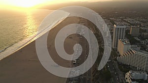 AERIAL: High up view of Pacific Coast Highway PCH next to Santa Monica Pier, Los Angeles with light traffic and ocean