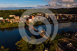 Aerial of Historic Wheeling Suspension Bridge + Downtown Buildings - Ohio River - Wheeling, West Virginia