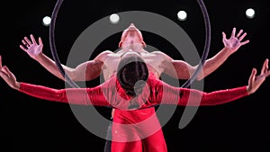 Aerial hoop duo on black background doing performance in slow motion. Concept of romantic relationship in couple