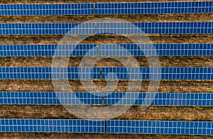 Aerial horizontal photo - top view of huge Solar Energy Plant on field in Europe - with beautiful sunlight on sunset