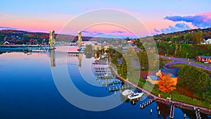 Aerial of Houghton harbor with boats and fall trees of gold, orange, green and red during sunrise