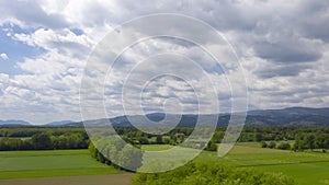 Aerial hyper lapse of rural landscape with hedges, meadows, and dramatic cloudscape