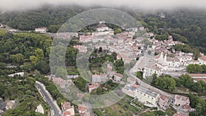Aerial of idyllic Sintra town on a foggy day. Charming white buildings.