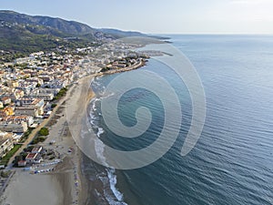 aerial image of the beach of El Cargador in Alcober with the Sierra of Irta Natural Park in the background, drone view