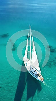 Aerial image of beautiful sailboat cruising in blue open ocean. Luxury white yacht. Generative AI