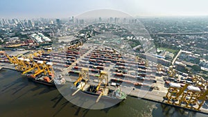 Aerial image of cargo ships at seaport with city view