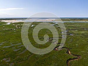 Aerial image of dutch national park slufter with curving rivers in grass land towards the north sea on the island of Texel