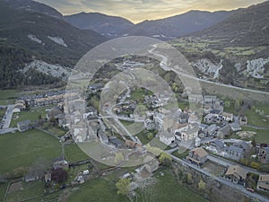 aerial image of a quiet village in a valley between mountains at sunset, with a road disappearing in the horizon, Fiscal, Huesca,