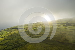 Aerial image showing a morning misty sunrise over the typical countryside of Sao Jorge Island, Azores photo