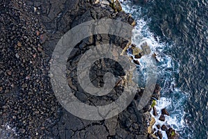 Aerial image showing the typical black lava basalt coastline of Ilha do Pico Island in the Azores photo