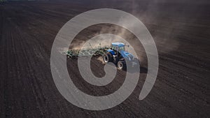 Aerial image of a tractor with seedbed cultivator ploughs field