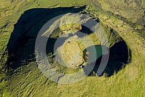 Aerial image of typical green volcanic caldera crater landscape with volcano cones of Planalto da Achada central plateau of Ilha