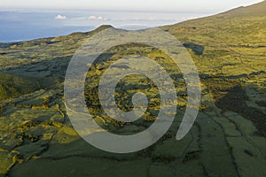 Aerial image of typical green volcanic caldera crater landscape with volcano cones of Planalto da Achada central plateau of Ilha