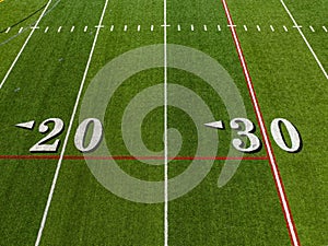 Aerial image of a typical synthetic turf football field 20-yard and 30-yard line in white