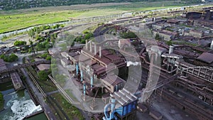 Aerial of industrial city with air atmosphere and river water pollution from metallurgical plant and blast furnaces near