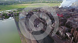 Aerial of industrial city with air atmosphere and river water pollution from metallurgical plant and blast furnaces near