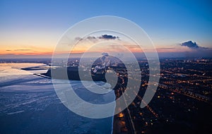 Aerial of industrial plant on the coast of a frozen Sea of Azov in Mariupol. Top view of the factory, smoke rising from